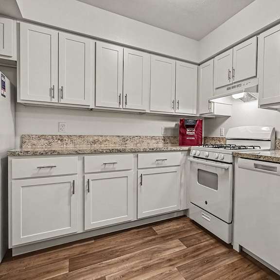 Thumbnail 10 of 24 A kitchen with white cabinets and appliances.