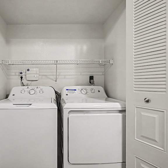 Thumbnail 16 of 24 A small laundry room with a washer and dryer in it.