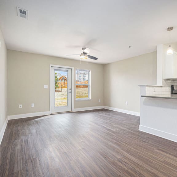 Thumbnail 3 of 10 a living room with a ceiling fan and a door to a private patio at Stoney Pointe Apartment Homes, Wichita, 67226