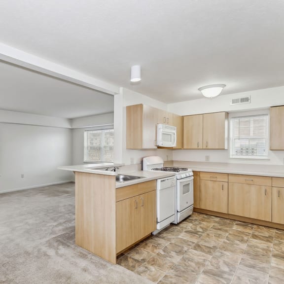 Thumbnail 3 of 7 an empty kitchen with wood cabinets and white appliances at Stoney Pointe Apartment Homes, Wichita, 67226
