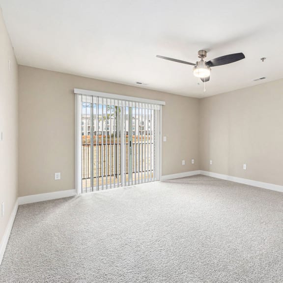 Thumbnail 3 of 12 an empty living room with a ceiling fan and a slider to a balcony at Stoney Pointe Apartment Homes, Wichita, KS, 67226