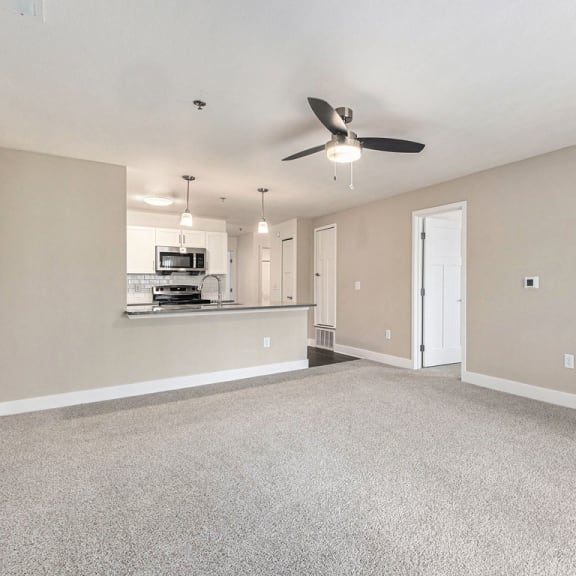 Thumbnail 4 of 12 an empty living room and kitchen with a ceiling fan at Stoney Pointe Apartment Homes, Wichita