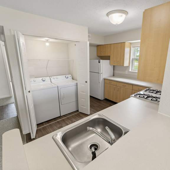 Thumbnail 9 of 13 A kitchen with a washer and dryer at Stoney Pointe Apartment Homes, Kansas