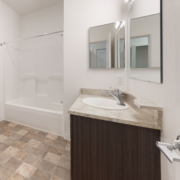 Thumbnail 14 of 14 a bathroom with a toilet and a sink and a shower at Strathmore Apartment Homes, Iowa