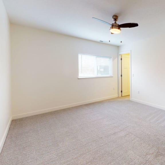 Thumbnail 12 of 14 an empty bedroom with a ceiling fan and a walk in closet at Strathmore Apartment Homes, West Des Moines
