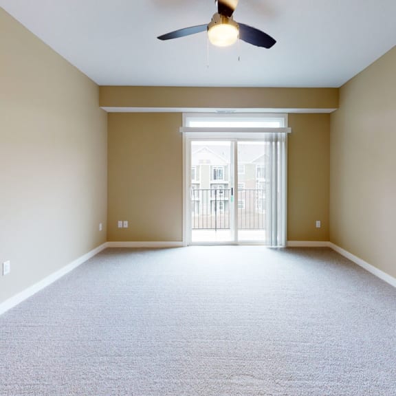 Thumbnail 5 of 14 A living room with a 9' ceiling and plush carpet at Strathmore Apartment Homes, Iowa, 50266