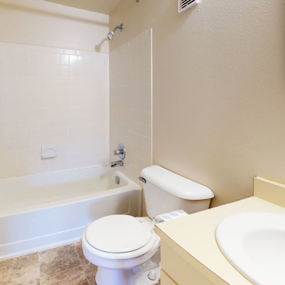 Thumbnail 7 of 10 a bathroom with a toilet and a tub and a sink at Swiss Valley Apartments, Michigan