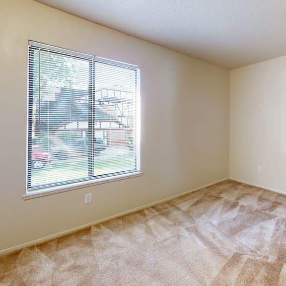 Thumbnail 8 of 10 an empty bedroom with a window and carpeting at Swiss Valley Apartments, Wyoming, MI