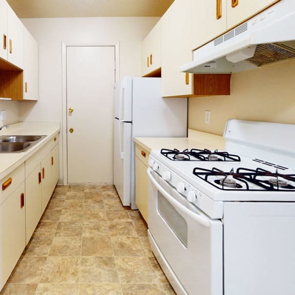 Thumbnail 6 of 10 a kitchen with a stove and sink and a refrigerator at Swiss Valley Apartments, Wyoming, MI, 49509