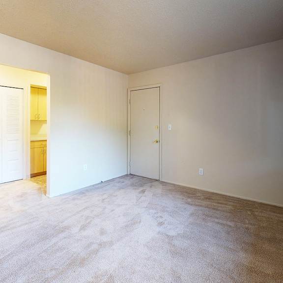 Thumbnail 5 of 9 A garden style living room with a carpeted floor at Swiss Valley Apartments in Wyoming, MI