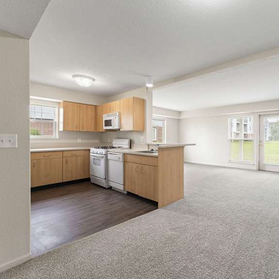 Thumbnail 3 of 15 A spacious kitchen with wooden cabinets and a white dishwasher at Tall Oaks Apartment Homes, Kalamazoo, MI