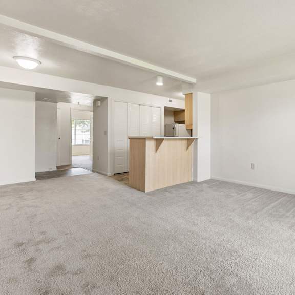 Thumbnail 4 of 9 A large, empty living room with a carpeted floor at Tall Oaks Apartment Homes, Kalamazoo, MI, 49009