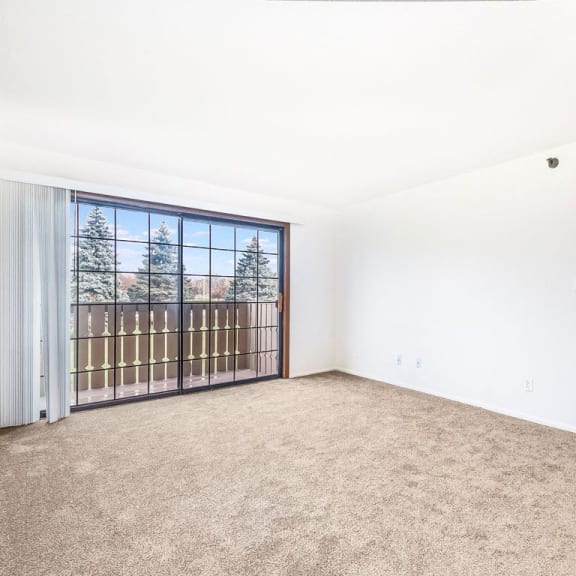 Thumbnail 5 of 20 an empty living room with a slider to a balcony at Tanglewood Apartments, Oak Creek, WI, 53154
