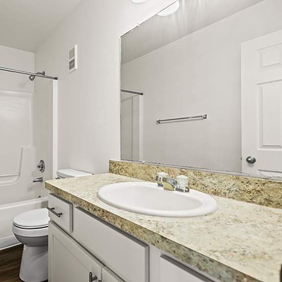Thumbnail 11 of 19 A white bathroom with a sink, toilet, and bathtub at Tanglewood Apartments, Oak Creek, WI