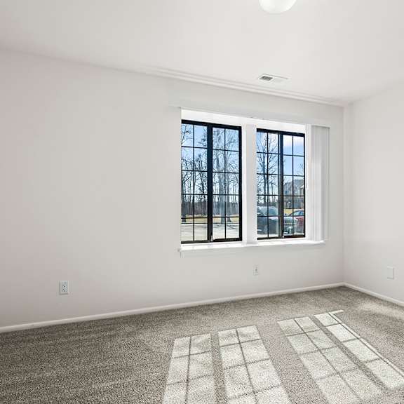 Thumbnail 18 of 19 A spacious bedroom with a large window and a carpeted floor at Tanglewood Apartments, Oak Creek, WI