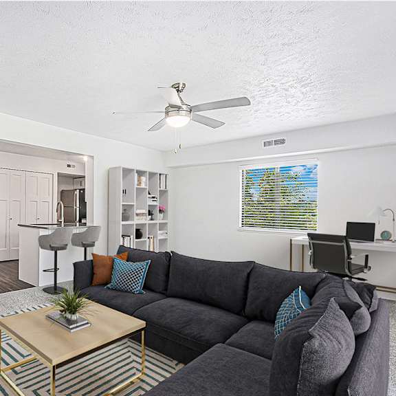 Thumbnail 4 of 9 enlarged living room with a ceiling fan at The Crossings Apartments, Michigan, 49508