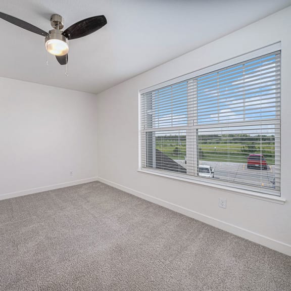 Thumbnail 17 of 17 bedroom with a large window and a ceiling fan at Trade Winds Apartment Homes, Elkhorn, NE