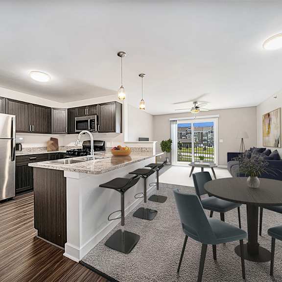 Thumbnail 3 of 11 A kitchen with a refrigerator, a counter, and a dining table at Trade Winds Apartment Homes, Elkhorn, NE