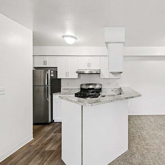 Thumbnail 5 of 11 A kitchen with a breakfast bar and a dining room at Trappers Cove Apartments, Lansing