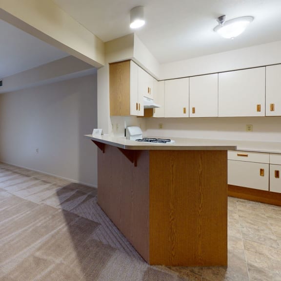Thumbnail 4 of 6 an empty living room and kitchen with a sliding glass door at Trillium Pointe Apartment Homes, Michigan