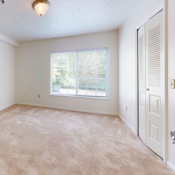 Thumbnail 6 of 7 an empty living room with a window and a door at Trillium Pointe Apartment Homes, Jackson, MI