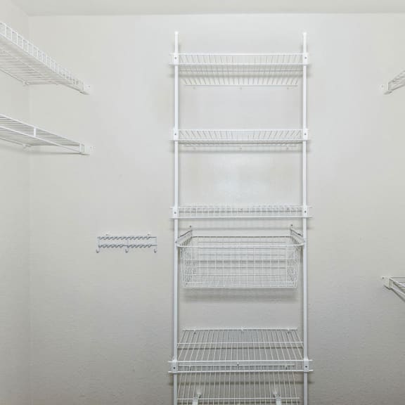 Thumbnail 7 of 7 a walk in closet with white walls and white metal shelves at Trillium Pointe Apartment Homes, Michigan, 49201