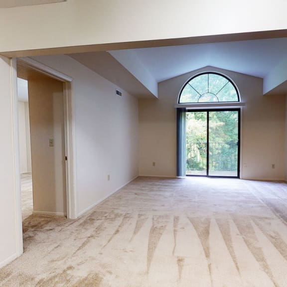 Thumbnail 4 of 12 an empty living room with white walls and a large window at Trillium Pointe Apartment Homes, Jackson, 49201