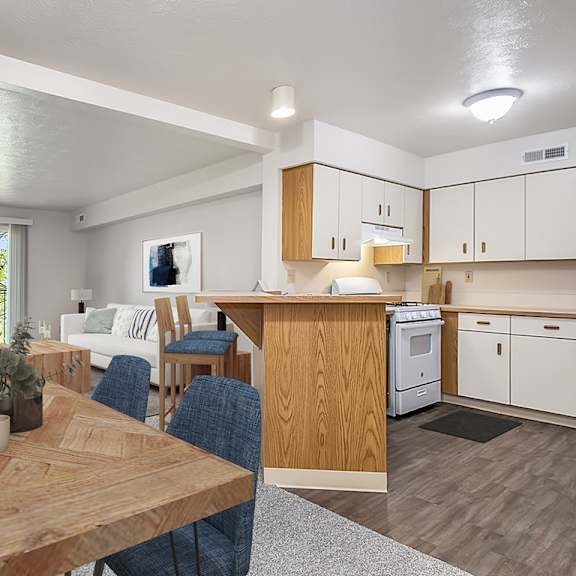 Thumbnail 3 of 7 A modern kitchen with a dining table and chairs at Trillium Pointe Apartment Homes, Jackson