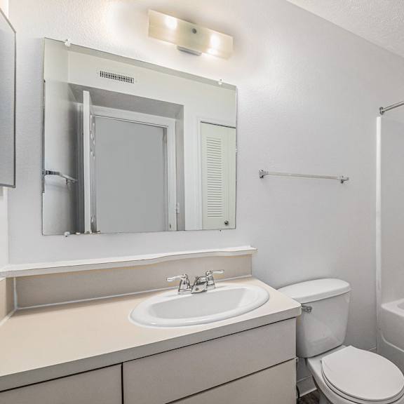 Thumbnail 11 of 19 A white bathroom with a toilet, sink, and bathtub at Trillium Pointe Apartment Homes, Michigan, 49201