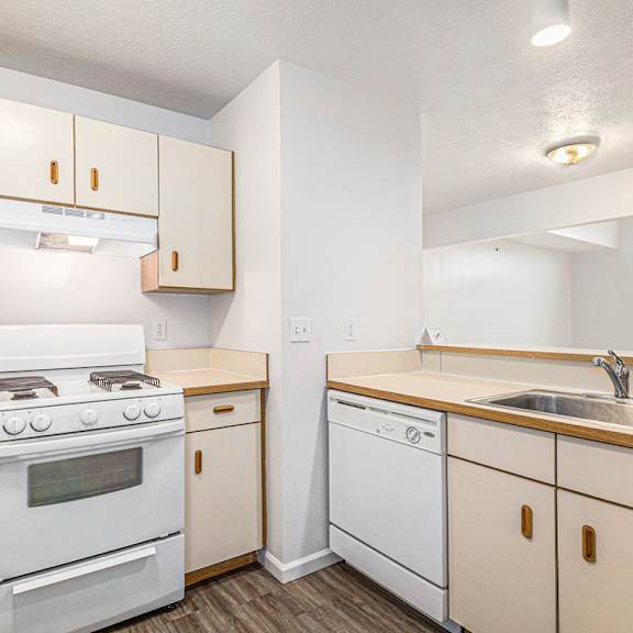 Thumbnail 9 of 19 A kitchen with a white range and dishwasher at Trillium Pointe Apartment Homes, Michigan, 49201