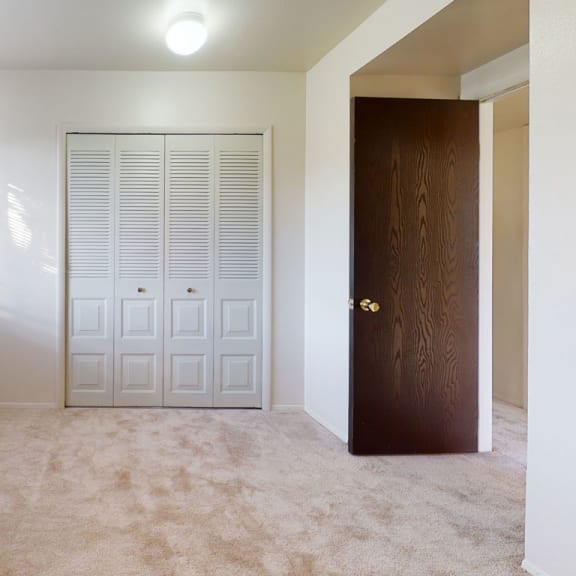 Thumbnail 7 of 7 A bedroom with a large window and closet at Walnut Trail Apartments, Portage, MI, 49002