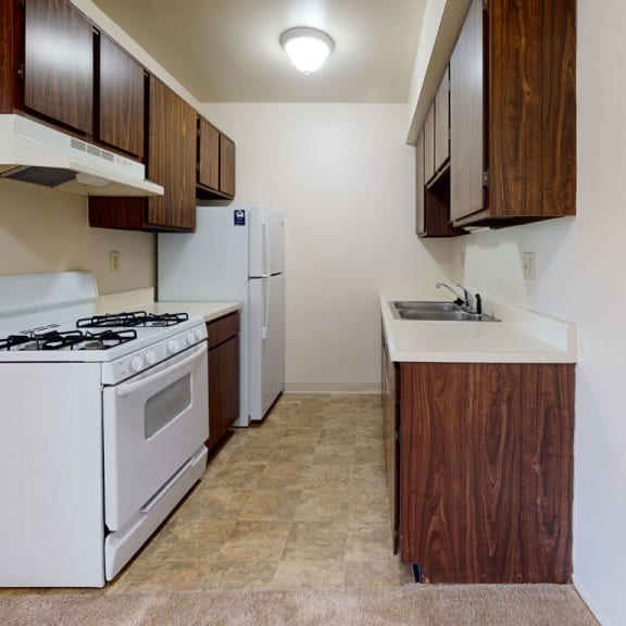 Thumbnail 5 of 7 a kitchen with a stove refrigerator and a sink at Walnut Trail Apartments, Portage, MI