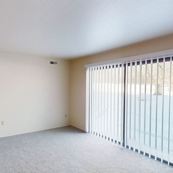 Thumbnail 3 of 8 the spacious living room has a large window with blinds at Walnut Trail Apartments, Portage
