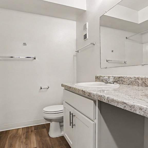 Thumbnail 9 of 11 A white bathroom with a large counter top and a toilet at Walnut Trail Apartments, Michigan