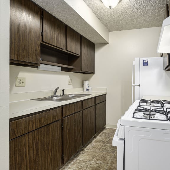 Thumbnail 8 of 11 Kitchen with gas stove and white appliances at Waverly Park Apartments in Lansing, MI 48911