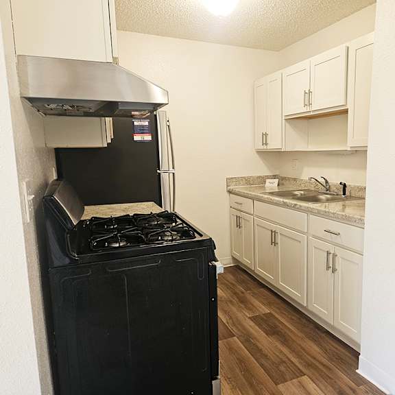Thumbnail 10 of 16 A stainless steel stove in a kitchen with white cabinets at Waverly Park Apartments, Lansing