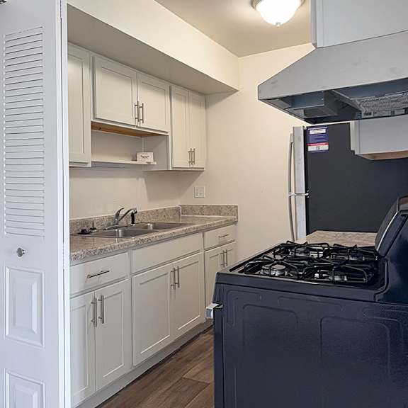 Thumbnail 7 of 12 A kitchen with stainless steel appliances and white cabinets at Waverly Park Apartments, Lansing