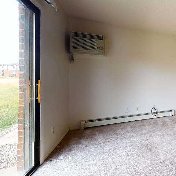 Thumbnail 3 of 12 A living and dining room with a carpeted floor and a window with blinds at Waverly Park Apartments, Lansing