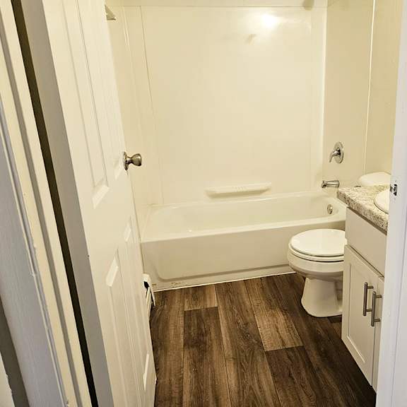 Thumbnail 11 of 15 A bathroom with a toilet, sink, and bathtub at Waverly Park Apartments, Lansing