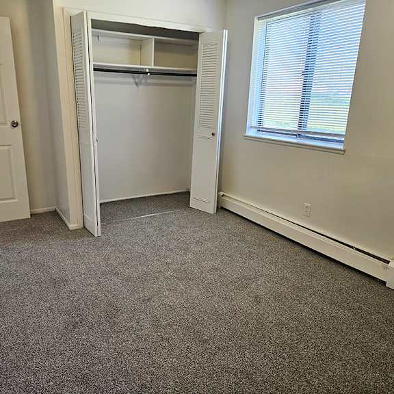 Thumbnail 14 of 15 A bedroom with a closet and a window at Waverly Park Apartments, Lansing