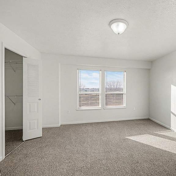 Thumbnail 17 of 17 A spacious bedroom with a carpeted floor and a window with blinds  at West Hampton Park Apartment Homes, Nebraska, 68022