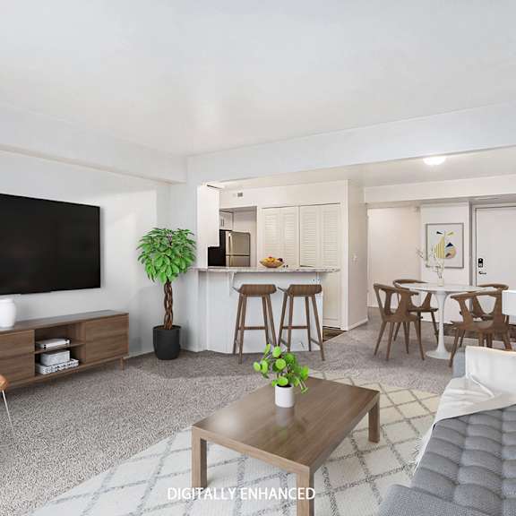 Thumbnail 3 of 14 A modern living room with a flat screen TV, a wooden chair, a coffee table, and a grey sofa at West Hampton Park Apartments in Elkhorn, NE 68022