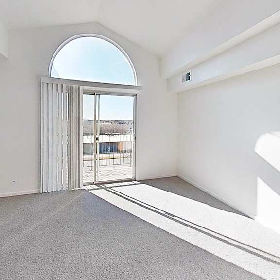 Thumbnail 6 of 17 A living room with a cathedral ceiling and a grey carpet at West Hampton Park Apartments in Elkhorn, NE 68022
