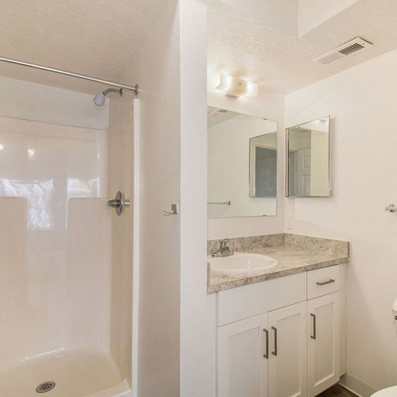 Thumbnail 20 of 20 A bathroom with a shower, toilet, and sink at West Hampton Park Apartments in Elkhorn, NE 68022