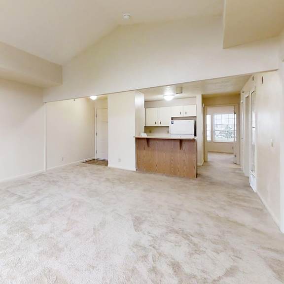Thumbnail 7 of 20 A large empty dining room with a kitchen area in the background at West Hampton Park Apartment Homes, Elkhorn, Nebraska 68022