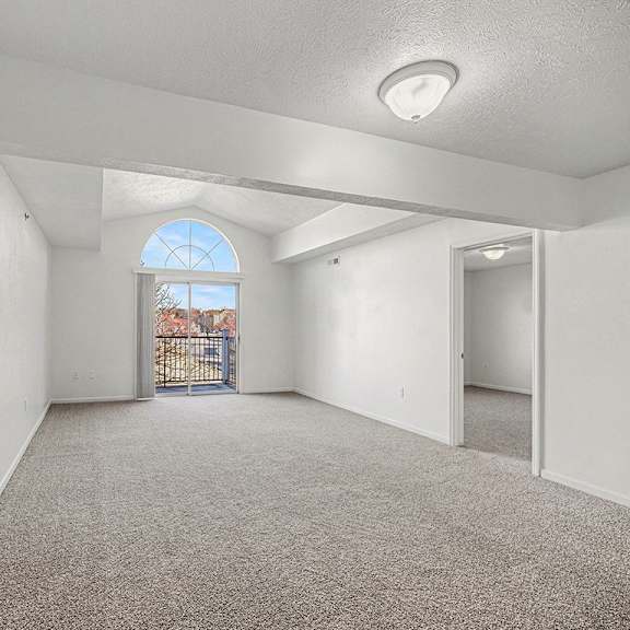 Thumbnail 3 of 19 A spacious living room with a large window and a door leading to a balcony  at West Hampton Park Apartment Homes, Nebraska, 68022