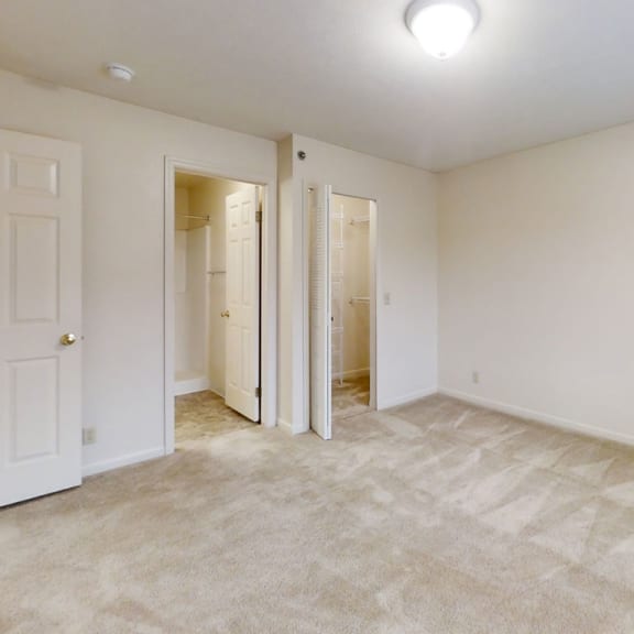 Thumbnail 18 of 20 A bedroom with doors to a walk in closet and an ensuite at West Hampton Park Apartment Homes, Nebraska