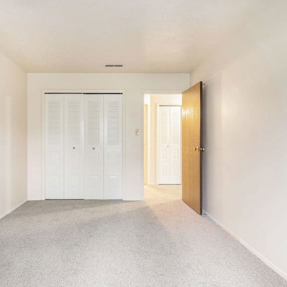 Thumbnail 12 of 12 A bedroom with a large closet and plush carpeting at Wingate Apartments, Kentwood, Michigan