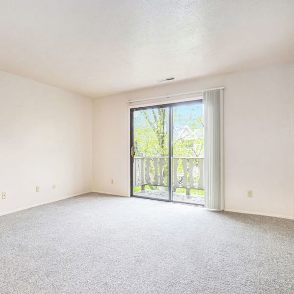 Thumbnail 4 of 12 A living room with a slider to a private balcony at Wingate Apartments, Kentwood, MI