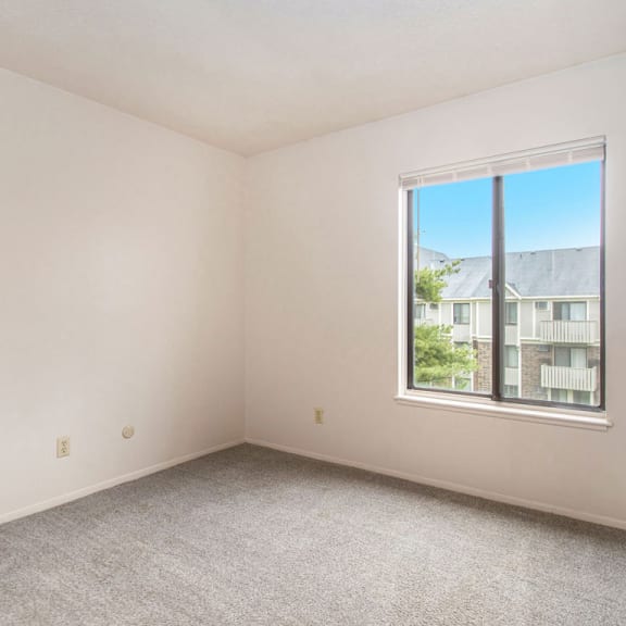 Thumbnail 11 of 13 A bedroom with a large window at Wingate Apartments, Kentwood, 49512